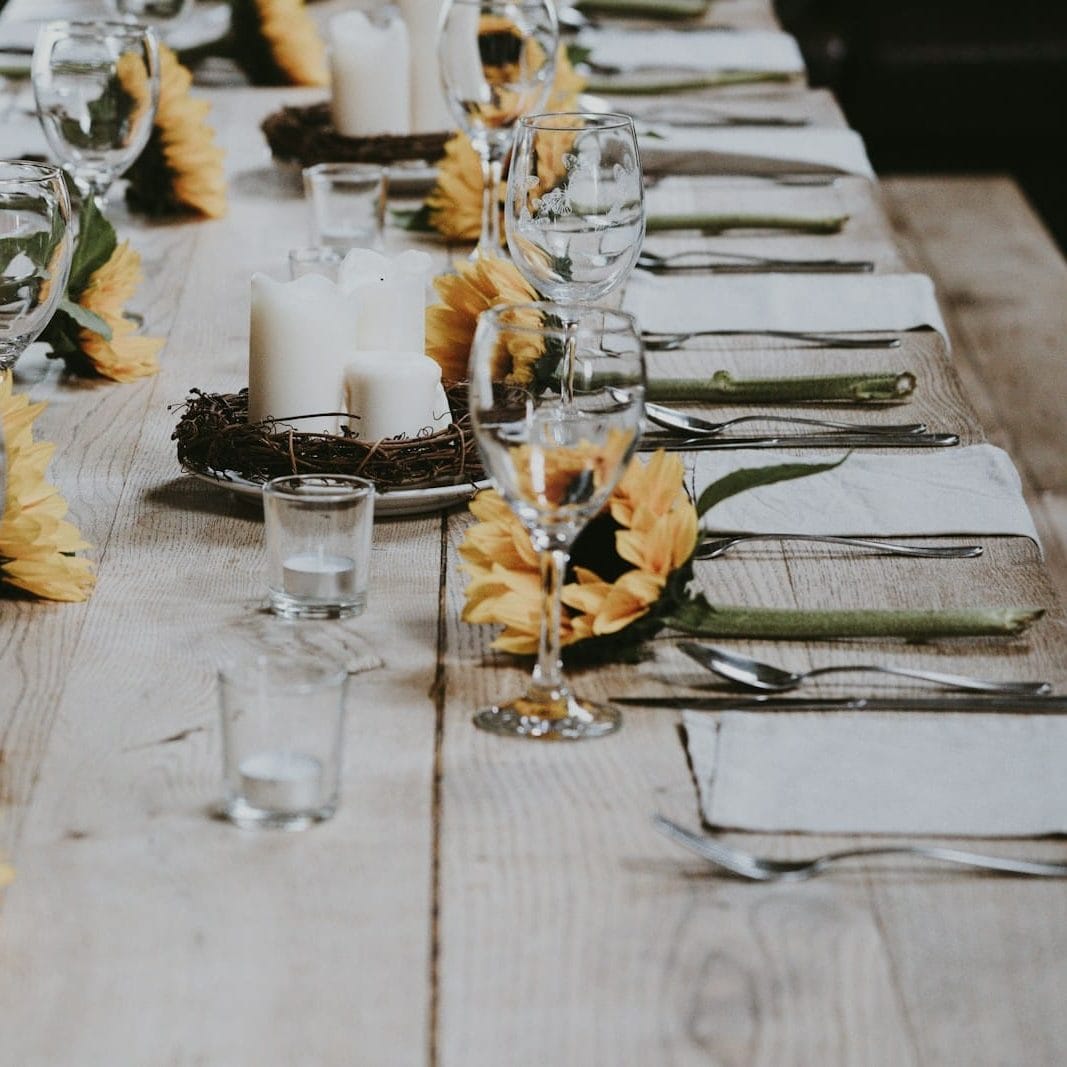 a set table with sunflowers and votives for decoration, generous table