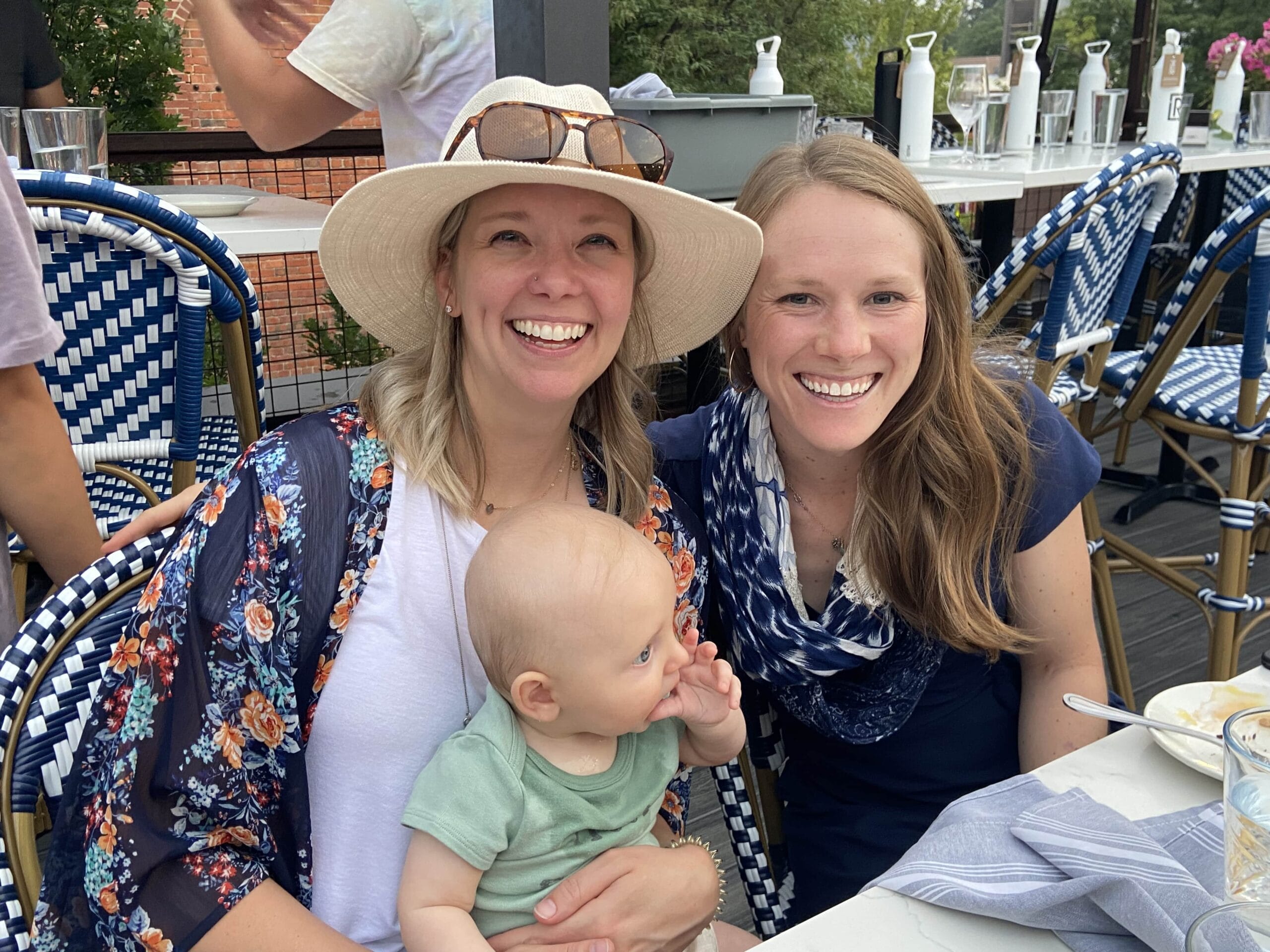 Two women and a baby smiling in the sunshine